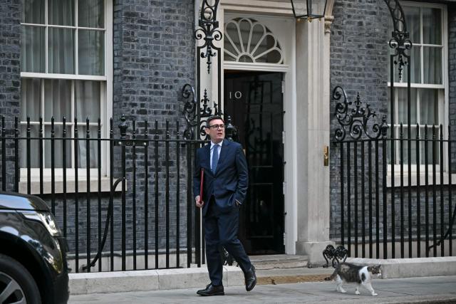 Larry the cat walks with Britain's Prime Minister Andy Burnham as he leaves 10 Downing Street in central London on October 14, 2026, to take part in the weekly session of 'Prime Minister's Questions' (PMQs) at parliament. (Photo by JUSTIN TALLIS / AFP)