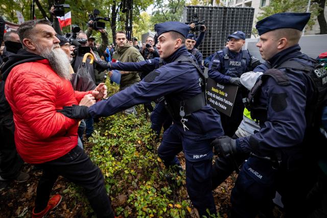 Police clash with anti-government protestors during a demonstration in front of the Constitutional Court, Poland's highest court, in Warsaw on October 14, 2026. Right-wing protestors clashed with police in front of Poland's highest court on October 14, attempting to block its judges from entering the building and defending its overhaul by the previous government. (Photo by Wojtek RADWANSKI / AFP)