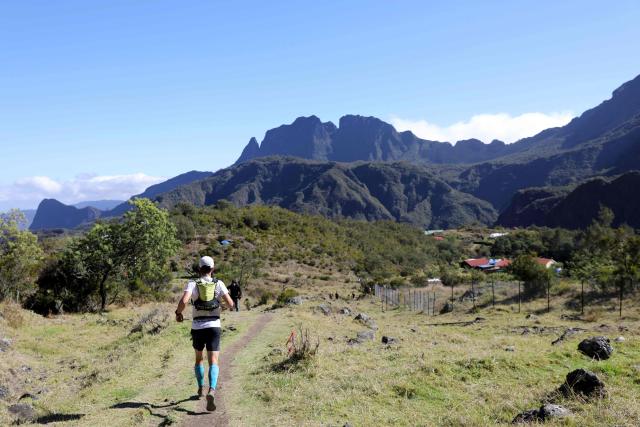 (FILES) A runner competes in the Grand Raid de la Reunion ultramarathon race (also called La diagonale des fous) on October 18, 2019 in the Cirque de Mafate caldera on the French Indian ocean island of La Reunion. About 3,000 amateur and experienced runners will set out on Thursday for the Diagonale des Fous, a trail race covering approximately 180 kilometers with 10,200 meters of elevation gain across Réunion, whose course has been extended this year. (Photo by Richard BOUHET / AFP)