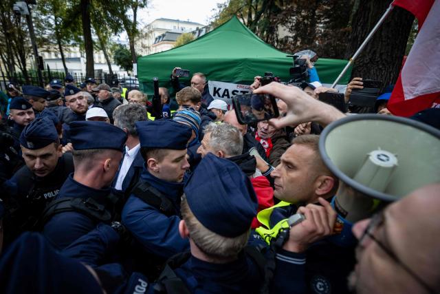 Police clash with anti-government protestors during a demonstration in front of the Constitutional Court, Poland's highest court, in Warsaw on October 14, 2026. Right-wing protestors clashed with police in front of Poland's highest court on October 14, attempting to block its judges from entering the building and defending its overhaul by the previous government. (Photo by Wojtek RADWANSKI / AFP)