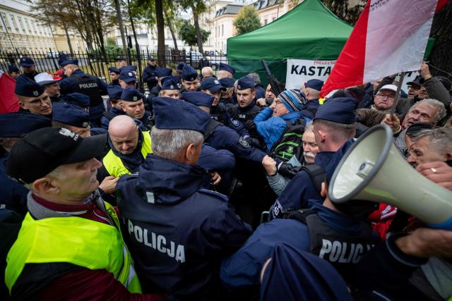 Police clash with anti-government protestors during a demonstration in front of the Constitutional Court, Poland's highest court, in Warsaw on October 14, 2026. Right-wing protestors clashed with police in front of Poland's highest court on October 14, attempting to block its judges from entering the building and defending its overhaul by the previous government. (Photo by Wojtek RADWANSKI / AFP)