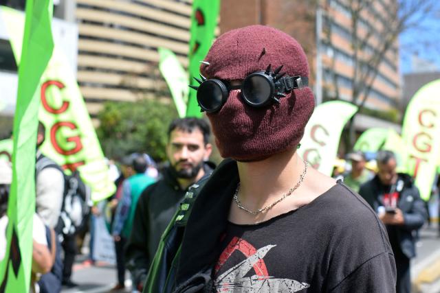 A demonstrator wearing a knit mask and protective goggles attends a protest against the government of Colombian President Abelardo de la Espriella in Bogota on October 14, 2026, as part of a nationwide day of demonstrations called by labor unions, teachers' organizations, student groups and opposition sectors. (Photo by Sebastian BARROS / AFP)