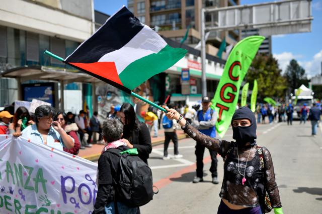 A demonstrator waves a Palestinian flag during a protest against the government of Colombian President Abelardo de la Espriella in Bogota on October 14, 2026, as part of a nationwide day of demonstrations called by labor unions, teachers' organizations, student groups and opposition sectors. (Photo by Sebastian BARROS / AFP)