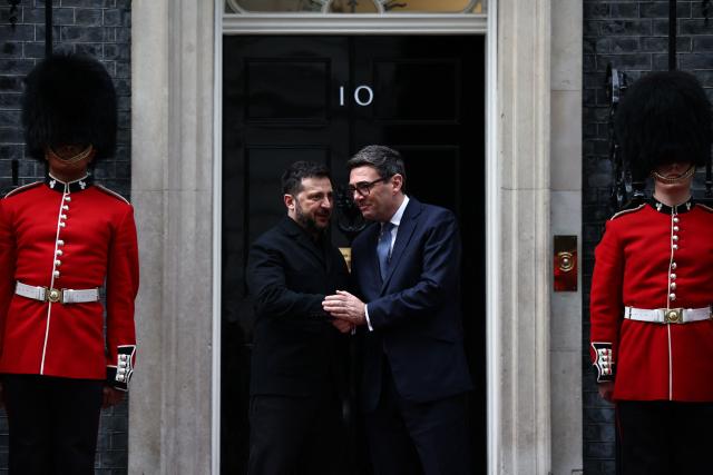 Britain's Prime Minister Andy Burnham (centre right) and Ukraine's President Volodymyr Zelensky (centre left) chat on the steps of 10 Downing Street flanked by members of the Irish guards in central London, on October 14, 2026, ahead of their meeting. (Photo by Henry Nicholls / POOL / AFP)