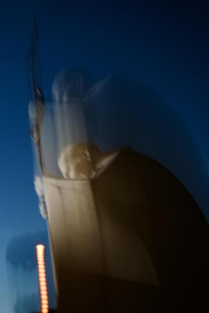 This photo captured with a slow shutter speed shows the statue of John Paul II outside the Gemelli University Hospital, where Pope Leo XIV is recovering after undergoing surgery to remove a cancerous tumour from his right lung, in Rome on October 14, 2026.  (Photo by Tiziana FABI / AFP)