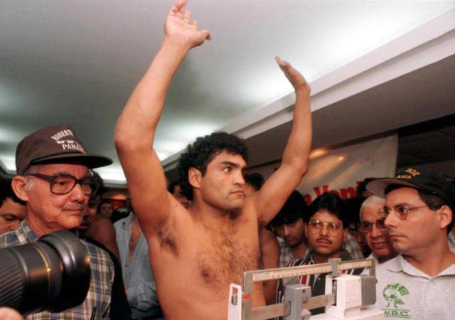 (FILES) Argentinian boxer Jorge "Locomotora" Castro (C) raises his arms after his weigh-in on June 14, 1997, in Panama City. The former Argentine boxer Jorge 'Roña' Castro, the 1994 middleweight world champion and the author of a memorable comeback victory over US boxer John David Jackson, died on October 14, 2026, at the age of 59 following a heart attack, according to his family. (Photo by ELIANA APONTE / AFP)