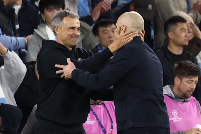 Paris Saint-Germain's Spanish head coach Luis Enrique (L) and Manchester City's Italian manager Enzo Maresca (R) embrace on the touchline on the final whistle in the UEFA Champions League, league phase football match between Manchester City and Paris Saint Germain at the Etihad Stadium in Manchester, north west England, on October 14, 2026. PSG won the game 4-2. (Photo by FRANCK FIFE / AFP)