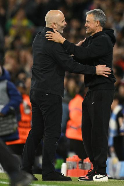 Paris Saint-Germain's Spanish head coach Luis Enrique (R) and Manchester City's Italian manager Enzo Maresca (L) embrace on the touchline on the final whistle in the UEFA Champions League, league phase football match between Manchester City and Paris Saint Germain at the Etihad Stadium in Manchester, north west England, on October 14, 2026. PSG won the game 4-2. (Photo by Oli SCARFF / AFP)