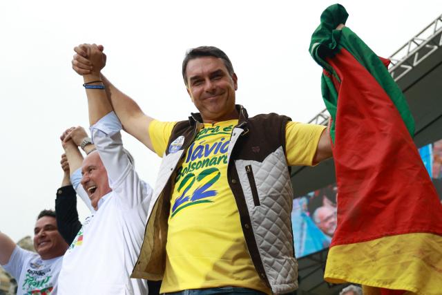 Brazil's right-wing senator and Liberal Party (PL) presidential candidate Flavio Bolsonaro holds the flag of Rio Grande do Sul during a rally at Largo Glenio Peres in Porto Alegre, Brazil, on October 14, 2026, ahead of the presidential election runoff. Bolsonaro heads to a runoff election with leftist President Luiz Inacio Lula da Silva on October 25, buoyed by sweeping gains in Congress, after a shock first-place finish. (Photo by SILVIO AVILA / AFP)