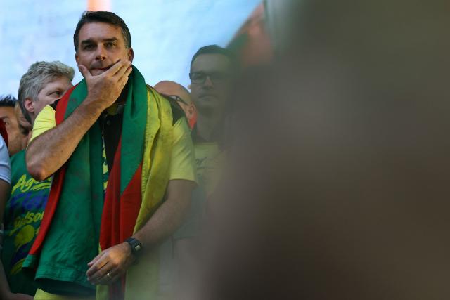 Brazil's right-wing senator and Liberal Party (PL) presidential candidate Flavio Bolsonaro gestures during a rally at Largo Glenio Peres in Porto Alegre, Brazil, on October 14, 2026, ahead of the presidential election runoff. Bolsonaro heads to a runoff election with leftist President Luiz Inacio Lula da Silva on October 25, buoyed by sweeping gains in Congress, after a shock first-place finish. (Photo by SILVIO AVILA / AFP)