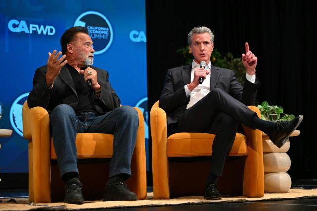 California Governor Gavin Newsom speaks while former governor and actor Arnold Schwarzenegger looks on at the California Economic Summit in Long Beach, California, on October 14, 2026. (Photo by Patrick T. Fallon / AFP)