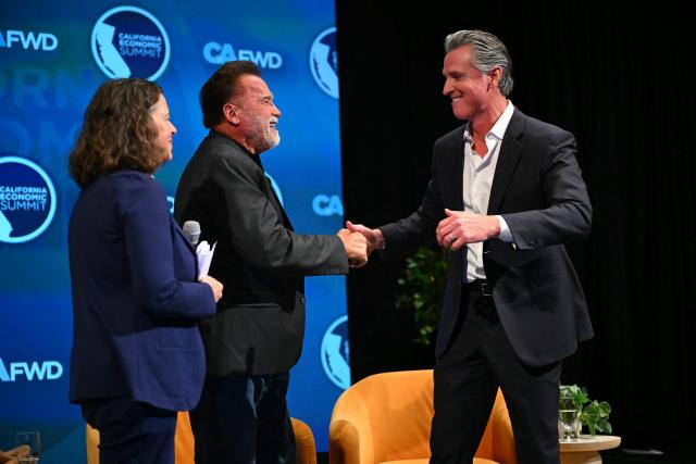 Former California governor and actor Arnold Schwarzenegger shakes hands with California governor Gavin Newsom during the California Economic Summit in Long Beach, California, on October 14, 2026. (Photo by Patrick T. Fallon / AFP)