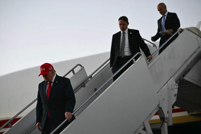 US President Donald Trump disembarks Air Force One at Glacier Park International Airport in Kalispell, Montana, on October 14, 2026. President Trump is travelling to Montana to speak at a campaign rally. (Photo by Kent NISHIMURA / AFP)