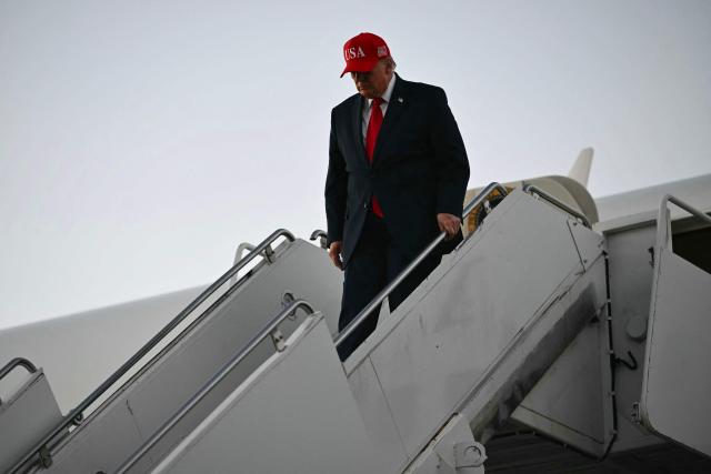 US President Donald Trump disembarks Air Force One at Glacier Park International Airport in Kalispell, Montana, on October 14, 2026. President Trump is travelling to Montana to speak at a campaign rally. (Photo by Kent NISHIMURA / AFP)