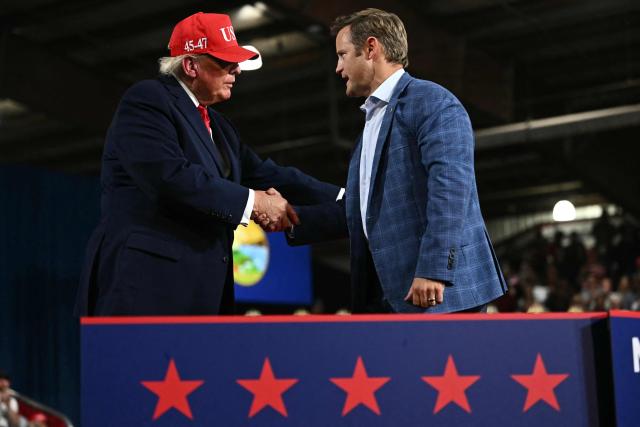 Republican candidate for US Congress Aaron Flint shakes hands with US President Donald Trump during a campaign rally at the Majestic Valley Arena in Kalispell, Montana on October 14, 2026. President Trump is campaigning for Flint. (Photo by Kent NISHIMURA / AFP)