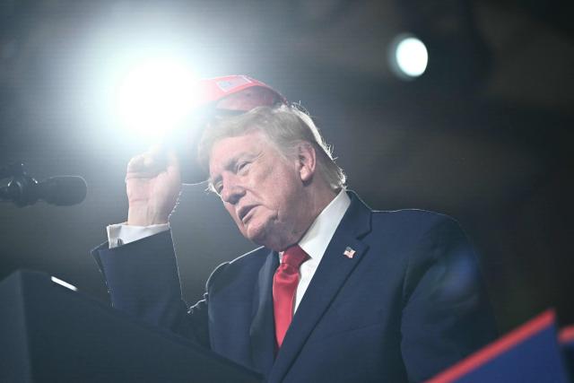 US President Donald Trump adjusts his hat during a campaign rally at the Majestic Valley Arena in Kalispell, Montana on October 14, 2026. President Trump is campaigning for US Congressional candidate Aaron Flint. (Photo by Kent NISHIMURA / AFP)
