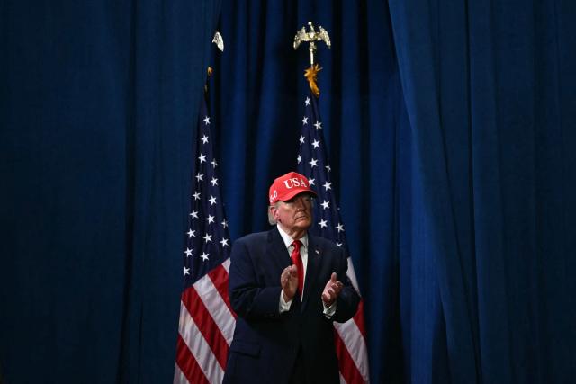 US President Donald Trump claps as he walks off stage during a campaign rally at the Majestic Valley Arena in Kalispell, Montana on October 14, 2026. President Trump is campaigning for US Congressional candidate Aaron Flint. (Photo by Kent NISHIMURA / AFP)