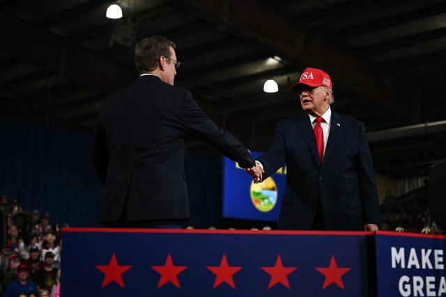 Republican candidate for US Senate Kurt Alme shakes hands with US President Donald Trump during a campaign rally at the Majestic Valley Arena in Kalispell, Montana on October 14, 2026. President Trump is campaigning for Aaron Flint and Alme. (Photo by Kent NISHIMURA / AFP)