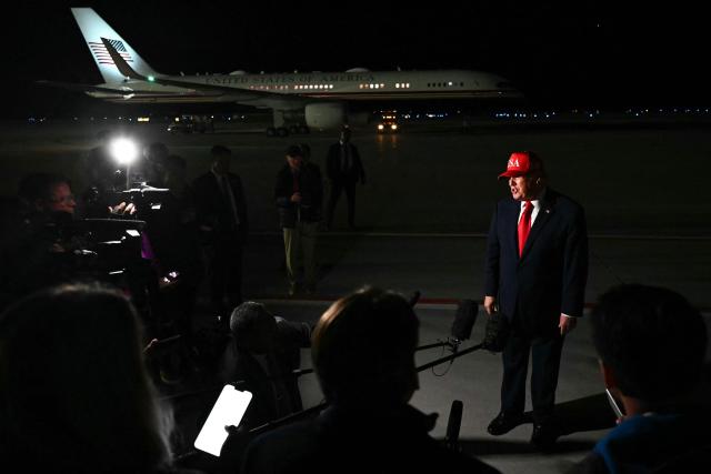 US President Donald Trump speaks with pool reporters during a stop over to switch planes at Missoula Montana Airport, in Missoula, Montana on October 14, 2026. President Trump is returning to Washington, DC after speaking at campaign rallies in Alaska, Arizona and Montana. (Photo by Kent NISHIMURA / AFP)