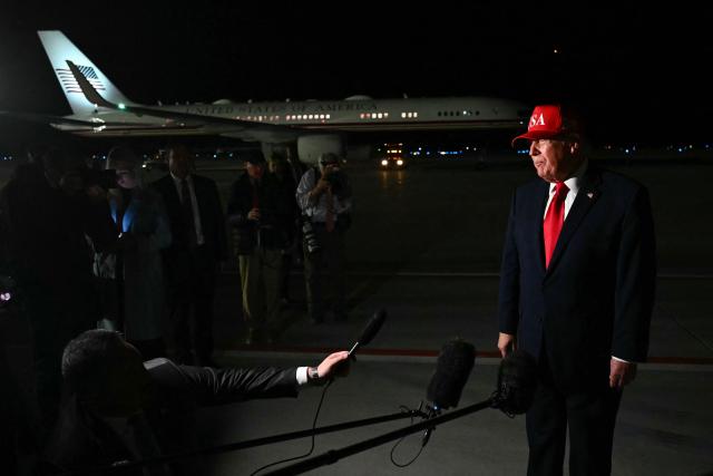 US President Donald Trump speaks with pool reporters during a stop over to switch planes at Missoula Montana Airport, in Missoula, Montana on October 14, 2026. President Trump is returning to Washington, DC after speaking at campaign rallies in Alaska, Arizona and Montana. (Photo by Kent NISHIMURA / AFP)