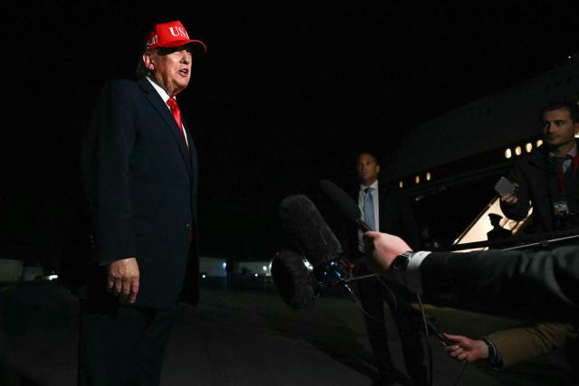 US President Donald Trump speaks with pool reporters during a stop over to switch planes at Missoula Montana Airport, in Missoula, Montana on October 14, 2026. President Trump is returning to Washington, DC after speaking at campaign rallies in Alaska, Arizona and Montana. (Photo by Kent NISHIMURA / AFP)