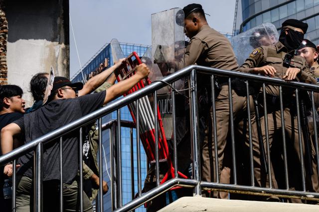 Police face off with demonstrators during a protest against the International Monetary Fund (IMF) and World Bank Group in Bangkok on October 15, 2026, as the IMF Annual Meetings take place in the Thai capital. (Photo by ANTHONY WALLACE / AFP)