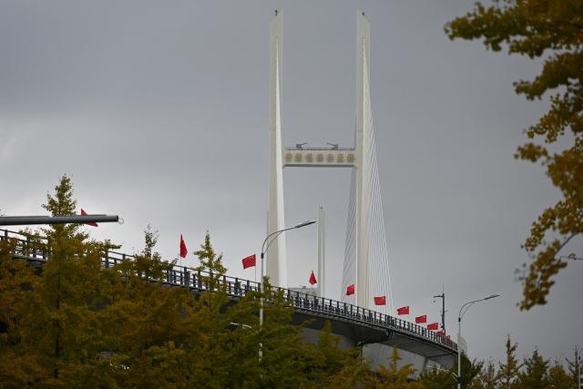 A general view shows the new cross-border bridge linking China and North Korea in Dandong, Liaoning Province, on October 15, 2026. A new four-lane road bridge linking China and North Korea finally opened on October 15, 12 years late, enabling the Asian giant and its isolated nuclear-armed neighbour to step up cross-border trade substantially. (Photo by Michael ZHANG / AFP)
