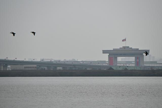 A general view shows the North Korean side of a new cross-border bridge linking China and North Korea, as seen from Dandong, Liaoning Province, on October 15, 2026. A new four-lane road bridge linking China and North Korea finally opened on October 15, 12 years late, enabling the Asian giant and its isolated nuclear-armed neighbour to step up cross-border trade substantially. (Photo by Michael ZHANG / AFP)