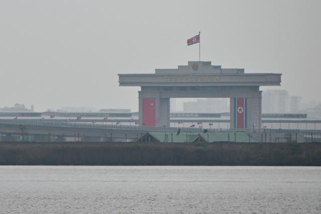 A general view shows the North Korean side of a new cross-border bridge linking China and North Korea, as seen from Dandong, Liaoning Province, on October 15, 2026. A new four-lane road bridge linking China and North Korea finally opened on October 15, 12 years late, enabling the Asian giant and its isolated nuclear-armed neighbour to step up cross-border trade substantially. (Photo by Michael ZHANG / AFP)