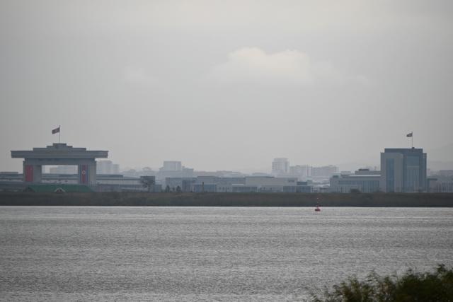 A general view shows North Korean territory on the other side of a new cross-border bridge linking China and North Korea, as seen from Dandong, Liaoning Province, on October 15, 2026. A new four-lane road bridge linking China and North Korea finally opened on October 15, 12 years late, enabling the Asian giant and its isolated nuclear-armed neighbour to step up cross-border trade substantially. (Photo by Michael ZHANG / AFP)