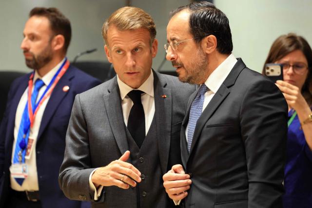 France's President Emmanuel Macron (C) and Cyprus' President Nikos Christodoulides speak together ahead of a round table as part of a European Union summit at the EU headquarters in Brussels on October 15, 2026. EU leaders head on October 15, 2026 for their biggest clash yet over the bloc's next long-term budget, as they race to lock in a deal before next year's French presidential election. (Photo by Ludovic MARIN / AFP)