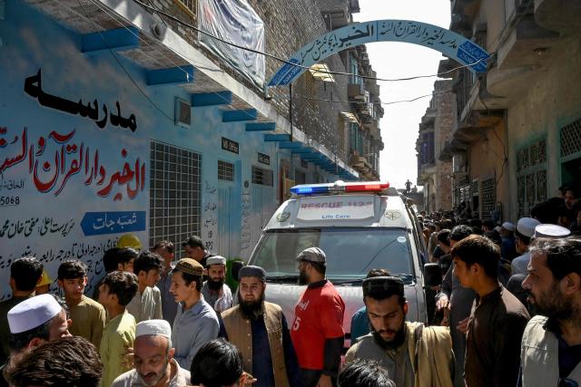 Residents gather during a search operation after a roof collapsed at a school in Peshawar on October 15, 2026. Sixteen pupils and a teacher were killed on October 15 after a roof collapsed at a school in the northwest Pakistani city of Peshawar, emergency services said. (Photo by Abdul MAJEED / AFP)