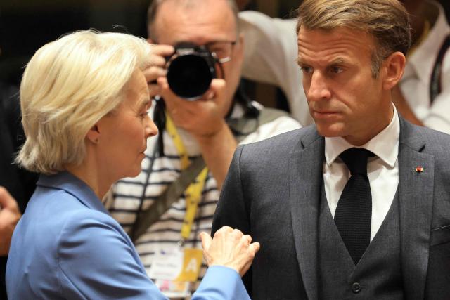 France's President Emmanuel Macron (R) and European Commission President Ursula von der Leyen speak together ahead of a round table as part of a European Union summit at the EU headquarters in Brussels on October 15, 2026. EU leaders head on October 15, 2026 for their biggest clash yet over the bloc's next long-term budget, as they race to lock in a deal before next year's French presidential election. (Photo by Ludovic MARIN / AFP)