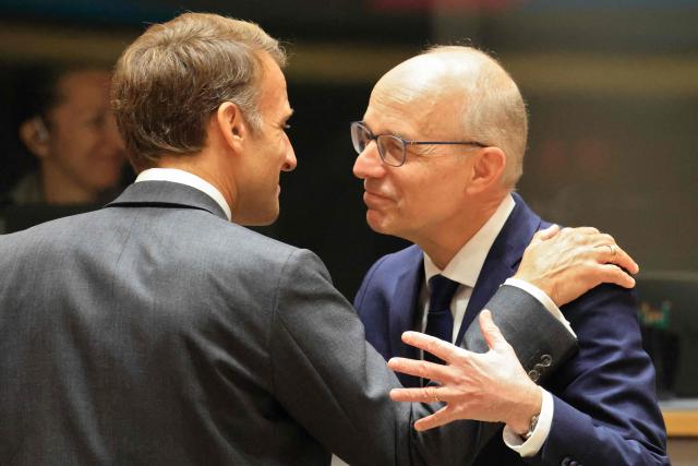 France's President Emmanuel Macron (L) greets Luxembourg's Prime Minister Luc Frieden ahead of a round table as part of a European Union summit at the EU headquarters in Brussels on October 15, 2026. EU leaders head on October 15, 2026 for their biggest clash yet over the bloc's next long-term budget, as they race to lock in a deal before next year's French presidential election. (Photo by Ludovic MARIN / AFP)