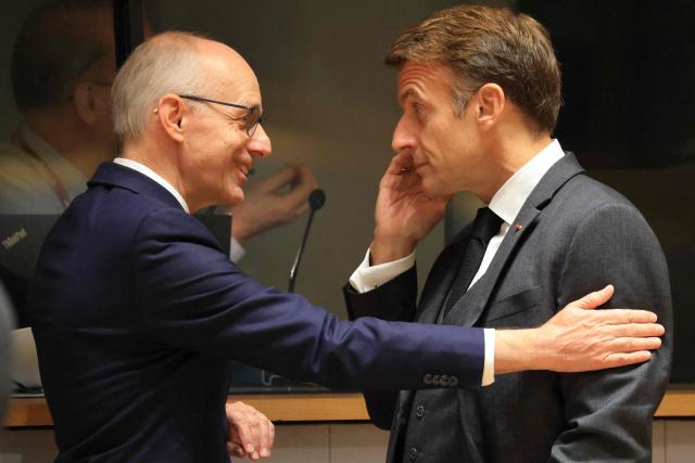 Luxembourg's Prime Minister Luc Frieden (L) and France's President Emmanuel Macron speak together ahead of a round table as part of a European Union summit at the EU headquarters in Brussels on October 15, 2026. EU leaders head on October 15, 2026 for their biggest clash yet over the bloc's next long-term budget, as they race to lock in a deal before next year's French presidential election. (Photo by Ludovic MARIN / AFP)