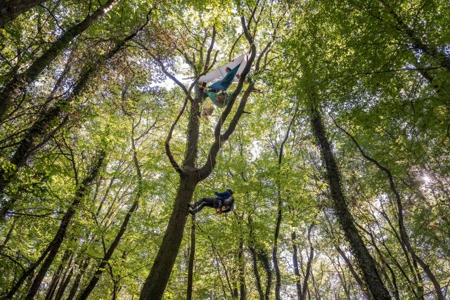 This photograph shows activists known as the "squirrels" perched in trees to prevent the trees from being cut down during the controversial construction of the A412 motorway, in a forest near Perrignier, Haute-Savoie, France, on October 14, 2026. A coalition of associations, farmers, and residents on October 14, 2026, sought to halt construction of the A412 motorway, arguing that its environmental impact runs “counter to the climate emergency.” While a court ruling is expected on October 15, 2026, protesters have staged near-daily demonstrations, resulting in dozens of detentions and fines, according to organizers. (Photo by Fabrice COFFRINI / AFP)