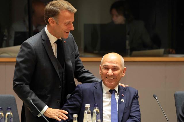 France's President Emmanuel Macron (L) greets Slovenia's Prime Minister Janez Jansa ahead of a round table as part of a European Union summit at the EU headquarters in Brussels on October 15, 2026. EU leaders head on October 15, 2026 for their biggest clash yet over the bloc's next long-term budget, as they race to lock in a deal before next year's French presidential election. (Photo by Ludovic MARIN / AFP)