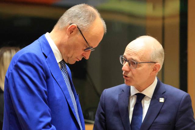 Germany's Chancellor Friedrich Merz (L) and Luxembourg's Prime Minister Luc Frieden speak together ahead of a round table as part of a European Union summit at the EU headquarters in Brussels on October 15, 2026. EU leaders head on October 15, 2026 for their biggest clash yet over the bloc's next long-term budget, as they race to lock in a deal before next year's French presidential election. (Photo by Ludovic MARIN / AFP)