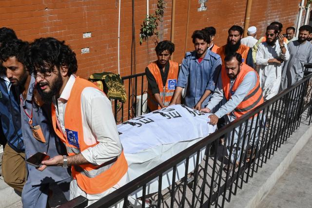 People shift the body of a victim, killed after a roof collapsed at a school, from a hospital in Peshawar on October 15, 2026. Twenty-seven pupils and a teacher were killed on October 15 after a roof collapsed at a school in the northwest Pakistani city of Peshawar, a hospital official said. (Photo by Abdul MAJEED / AFP)