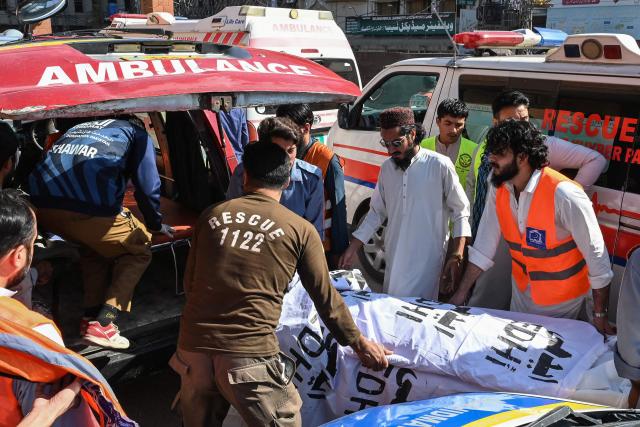 Volunteers and relatives shift the body of a victim, killed after a roof collapsed at a school, into an ambulance outside a hospital in Peshawar on October 15, 2026. Twenty-seven pupils and a teacher were killed on October 15 after a roof collapsed at a school in the northwest Pakistani city of Peshawar, a hospital official said. (Photo by Abdul MAJEED / AFP)