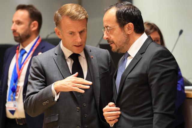 France's President Emmanuel Macron (C) and Cyprus' President Nikos Christodoulides speak together ahead of a round table as part of a European Union summit at the EU headquarters in Brussels on October 15, 2026. EU leaders head on October 15, 2026 for their biggest clash yet over the bloc's next long-term budget, as they race to lock in a deal before next year's French presidential election. (Photo by Ludovic MARIN / AFP)