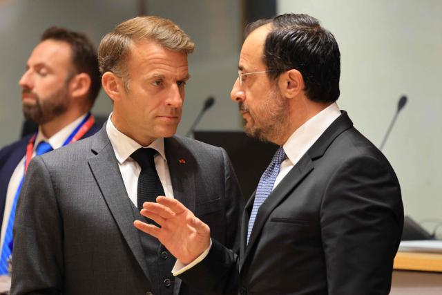 France's President Emmanuel Macron (C) and Cyprus' President Nikos Christodoulides speak together ahead of a round table as part of a European Union summit at the EU headquarters in Brussels on October 15, 2026. EU leaders head on October 15, 2026 for their biggest clash yet over the bloc's next long-term budget, as they race to lock in a deal before next year's French presidential election. (Photo by Ludovic MARIN / AFP)