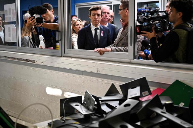 France's Education Minister Edouard Geffray (C) looks at damaged computer equipemtn during a visit to the Les Iris high school, which was partially ransacked by protesters on October 8 on the sidelines of a nationwide protest movement over learning conditions, in Lormont, a Bordeaux suburb, south-western France on October 15, 2026. (Photo by Christophe ARCHAMBAULT / AFP)