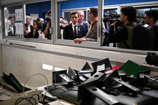 France's Education Minister Edouard Geffray (C) looks at damaged computer equipment during a visit to the Les Iris high school, which was partially ransacked by protesters on October 8 on the sidelines of a nationwide protest movement over learning conditions, in Lormont, a Bordeaux suburb, south-western France on October 15, 2026. (Photo by Christophe ARCHAMBAULT / AFP)