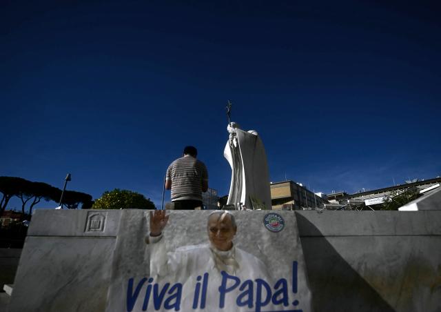 A banner 'Viva il Papa' is laid at the statue of John Paul II outside the Gemelli University Hospital, where Pope Leo XIV is recovering after undergoing surgery to remove a cancerous tumour from his right lung, in Rome on October 15, 2026 (Photo by Filippo MONTEFORTE / AFP)