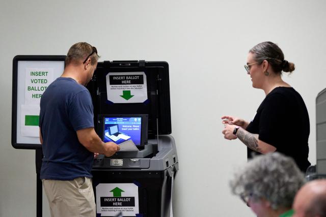 A voter casts his ballot at the NC State University Business Services building on the first day of early voting in Raleigh, North Carolina on October 15, 2026. Americans voting in the November 3 midterm elections will decide who controls Congress for the final two years of Donald Trump's presidency, along with dozens of governorships and thousands of state offices. (Photo by Matt RAMEY / AFP)