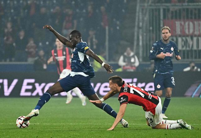 Salzburg's Togolese defender #44 Kevin Boma (L) and AC Milan's Italian forward #73 Francesco Camarda vie for the ball during the UEFA Europa League football match between Salzburg and AC Milan in Salzburg, on October 15, 2026. (Photo by Joe Klamar / AFP)
