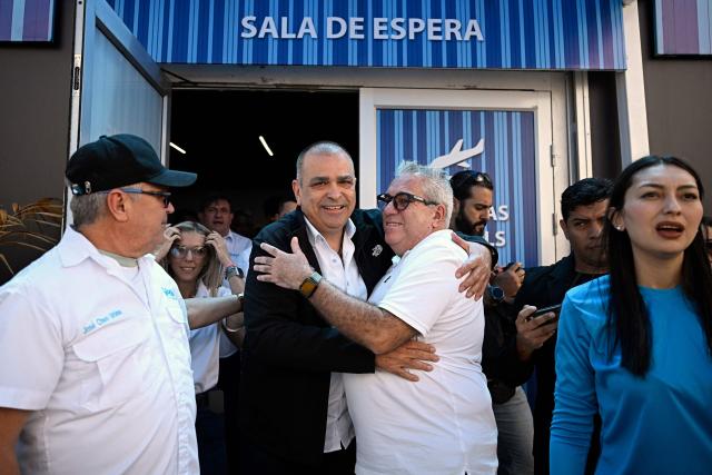 Gustavo Ruiz (2-L), state coordinator in Zulia for Vente Venezuela, the political party led by Venezuelan opposition leader Maria Corina Machado, is welcomed by party members upon his arrival at Simon Bolivar International Airport in Maiquetia, La Guaira state, Venezuela, on October 15, 2026, after a period in exile. (Photo by Federico PARRA / AFP)