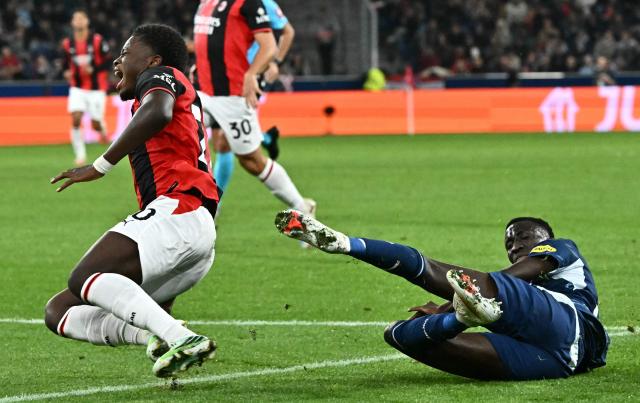 AC Milan's Italian midfielder #70 Alphadjo Cisse (L) falls over Salzburg's Gambian midfielder #32 Abubakr Barry during the UEFA Europa League football match between Salzburg and AC Milan in Salzburg, on October 15, 2026. (Photo by Joe Klamar / AFP)