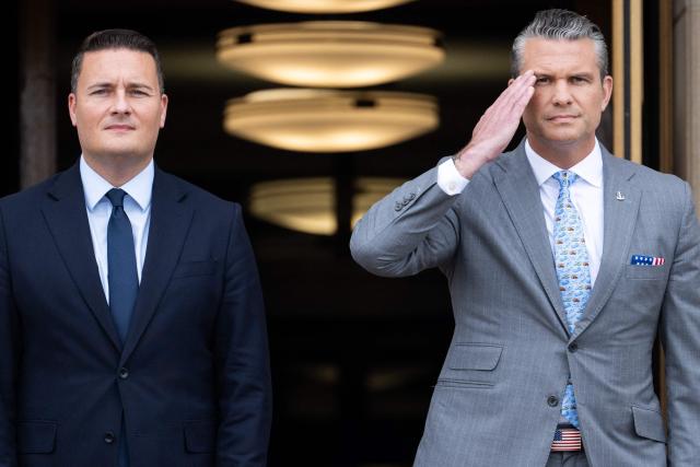 US Secretary of Defense Pete Hegseth salutes during a welcoming ceremony ahead of a meeting with UK Defense Secretary Wes Streeting (L) at the Pentagon in Washington, DC on October 15, 2026. (Photo by SAUL LOEB / AFP)